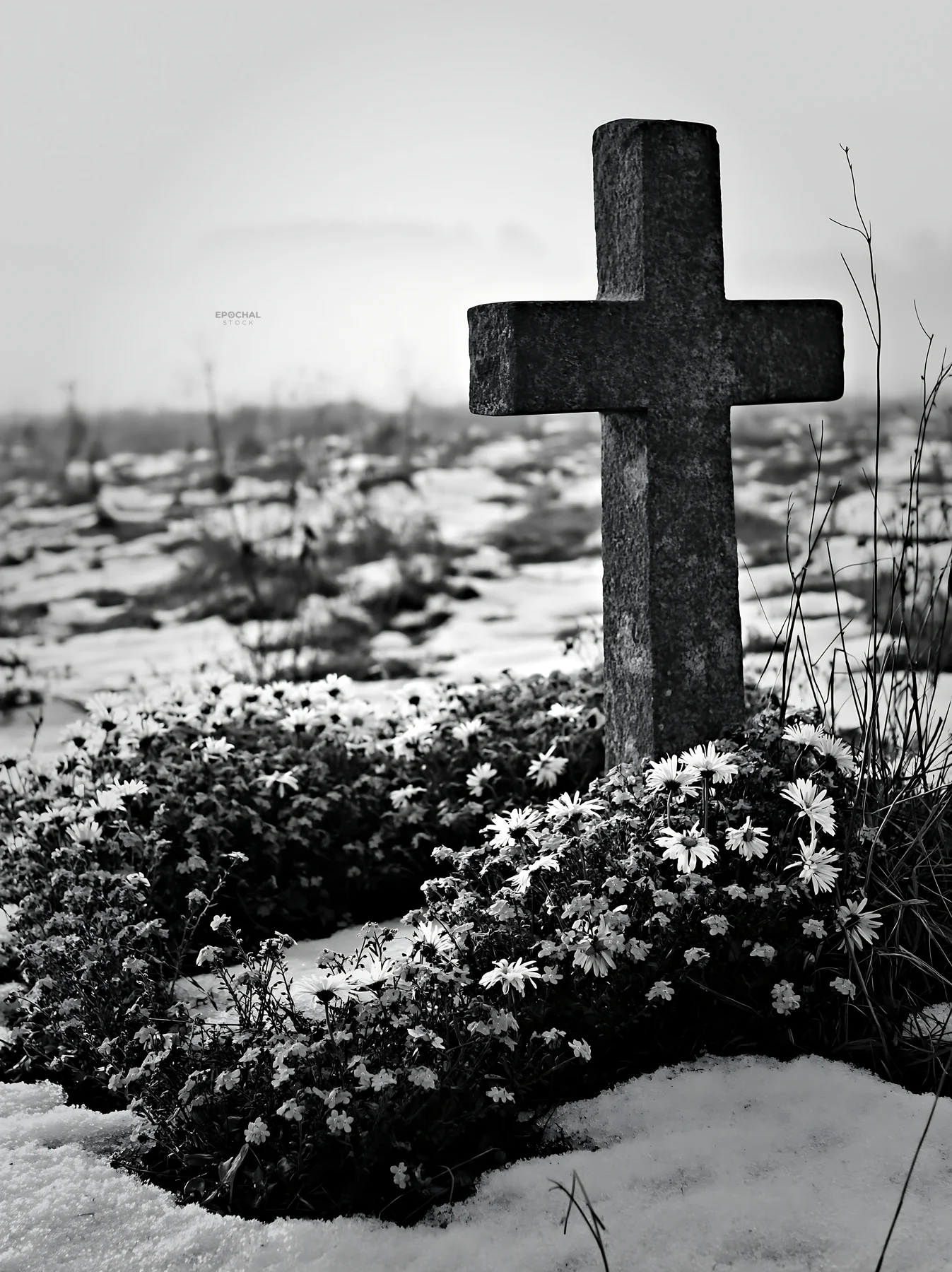 Stone Christian cross in snowy meadow with flowers - AI-generated stock image