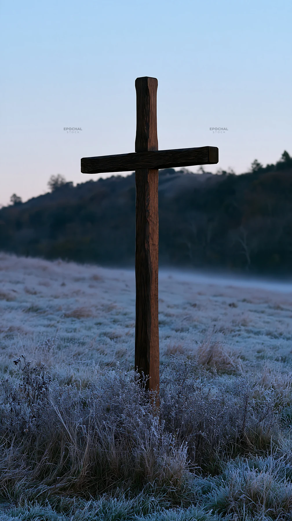 Carved oak cross standing in a frosted meadow at dawn - AI-generated stock image