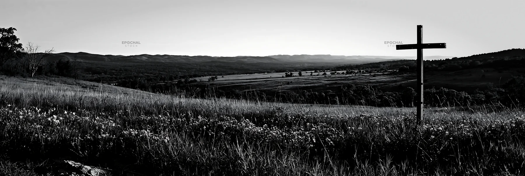 Iron Christian cross overlooking valley meadow - AI-generated stock image