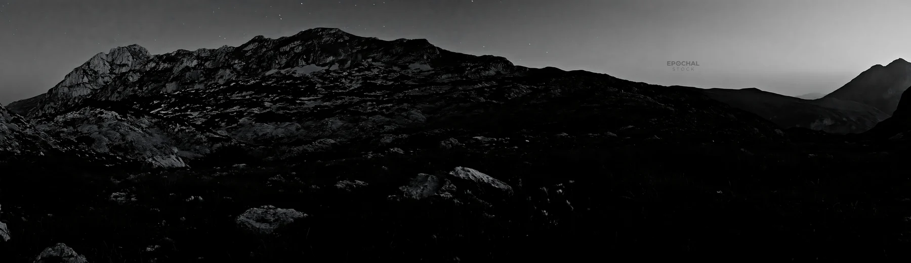 Starlit meadow with mountains in the background - AI-generated stock image