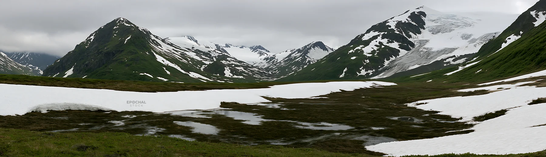 Snowmelt meadow in mountainous landscape with patches of snow - AI-generated stock image
