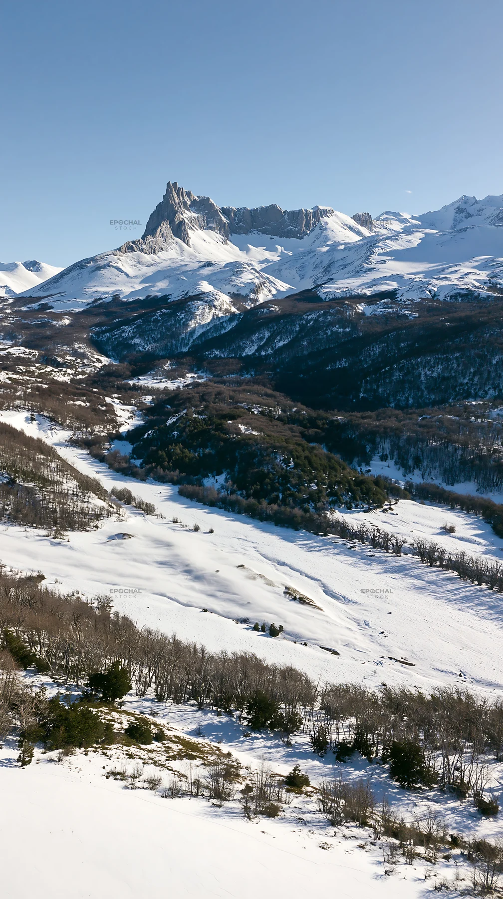 Aerial view snowy meadow valley shows mountains in the background - AI-generated stock image