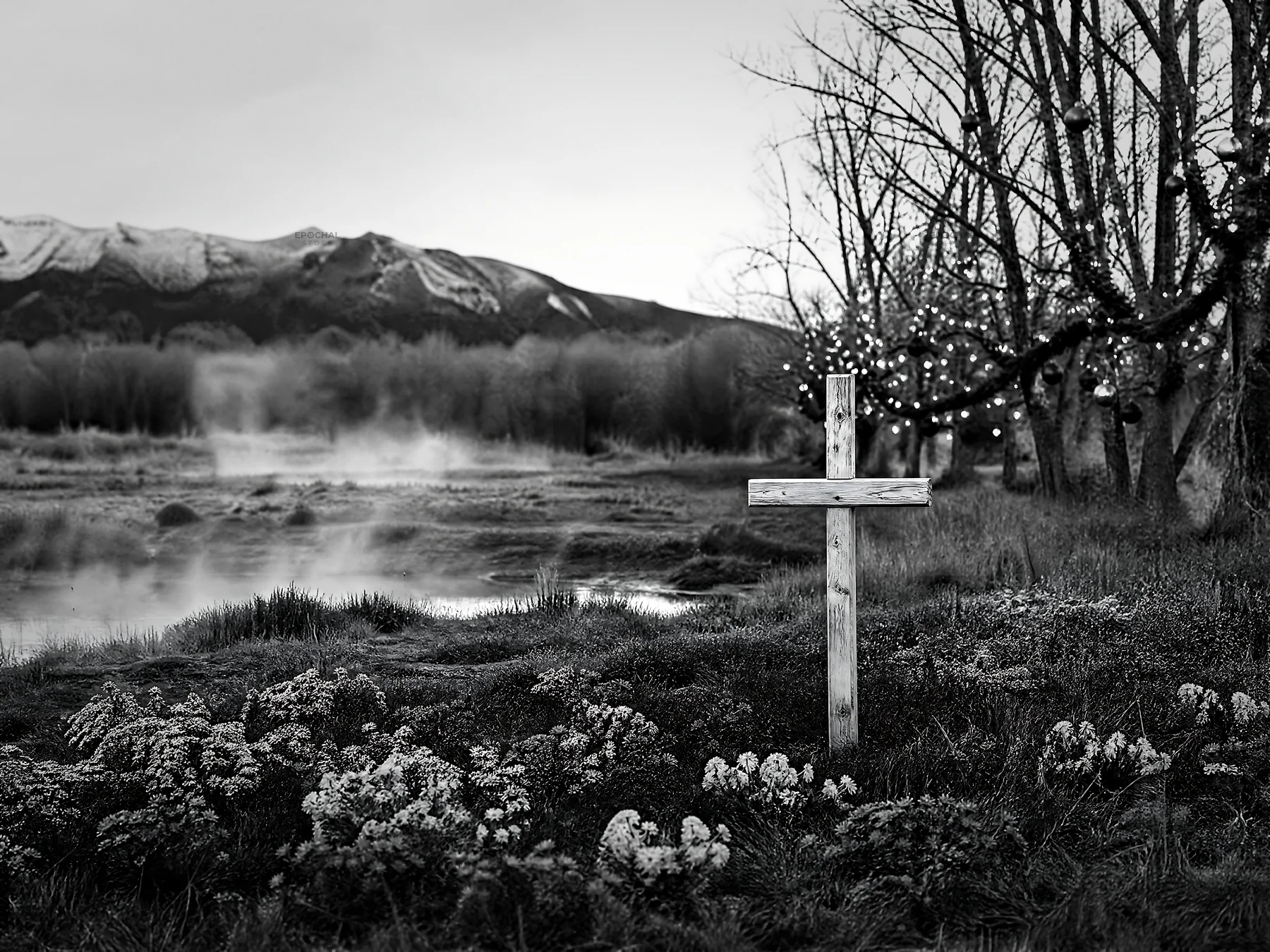 Wooden Christian cross in hot spring meadow near mountains - AI-generated stock image