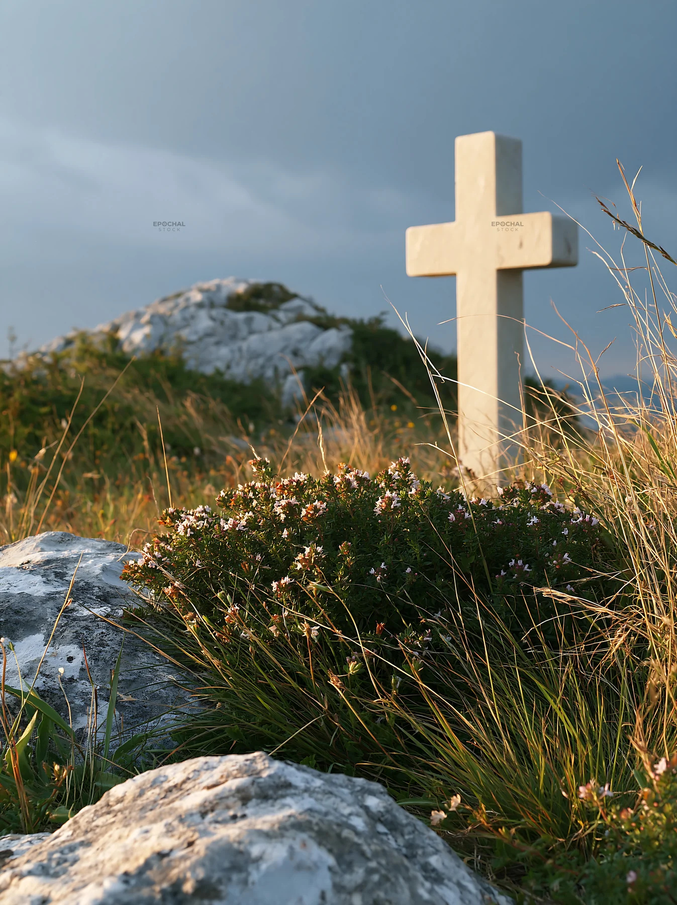 White Christian cross in remote meadow with rocks and grass - AI-generated stock image