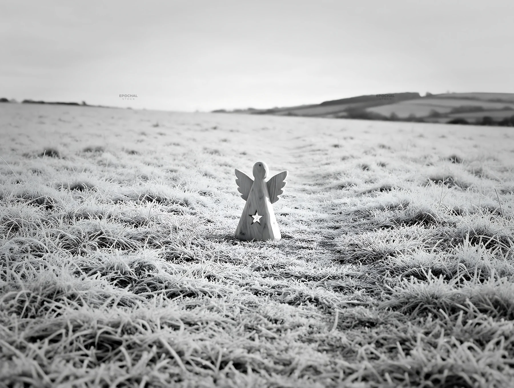 Meadow winter angel stands alone in a frosty landscape - AI-generated stock image