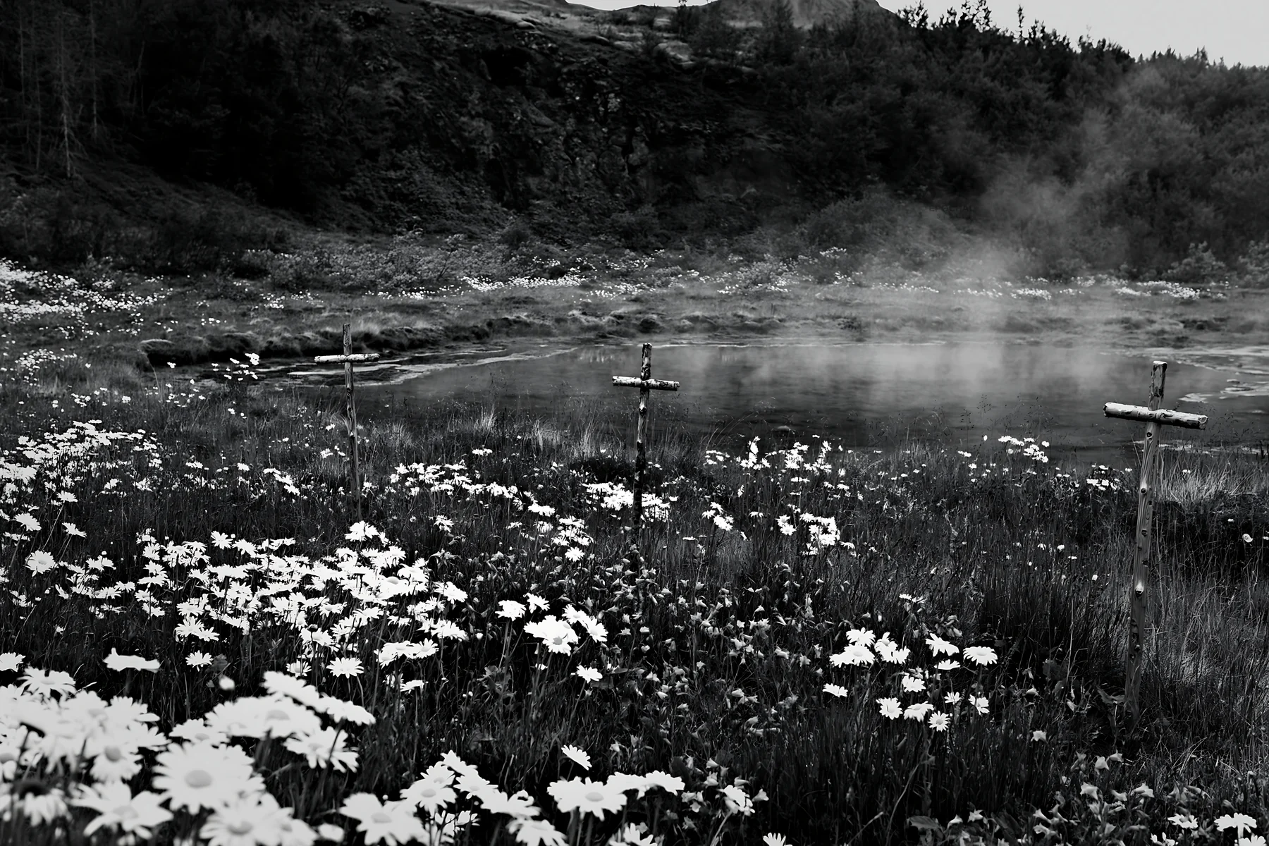 Christian crosses surrounded by flowers near geothermal spring