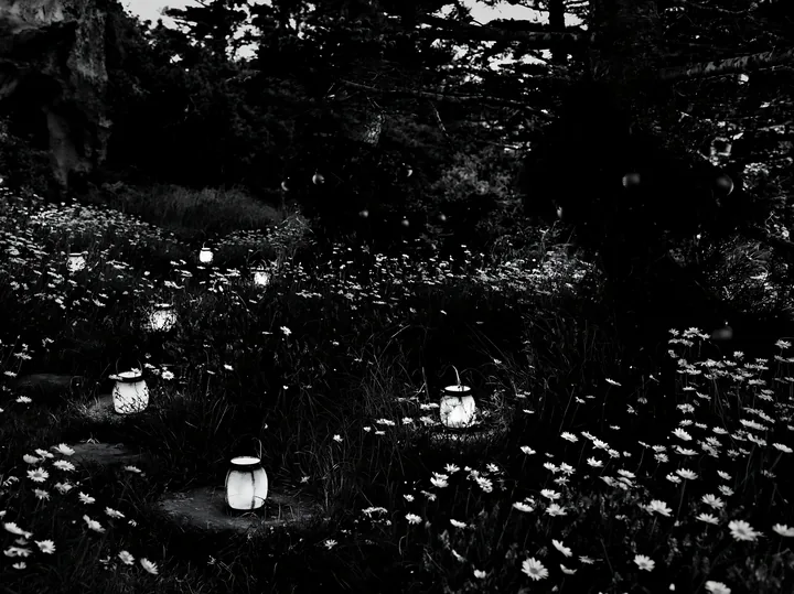 Christmas lanterns light meadow near cave at dusk - AI-generated stock image