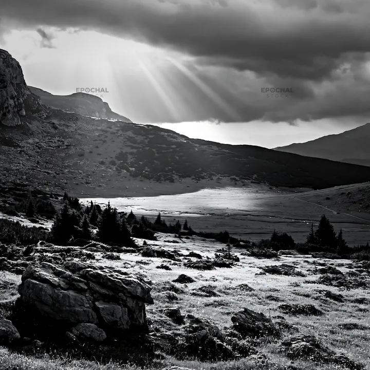 Light rays over a meadow in Bucegi Mountains during the day - AI-generated stock image