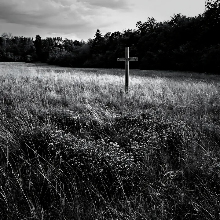 Wooden Christian cross in a Christmas meadow under cloudy sky - AI-generated stock image