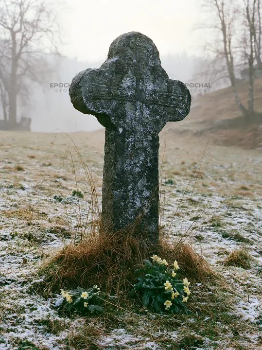 Stone Christian cross in snowy meadow - AI-generated stock image