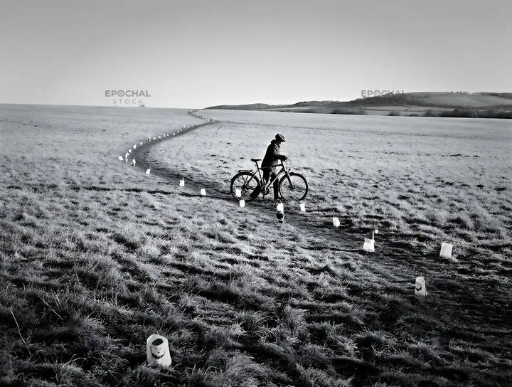 Biker in meadow with lanterns during daylight hours - AI-generated stock image