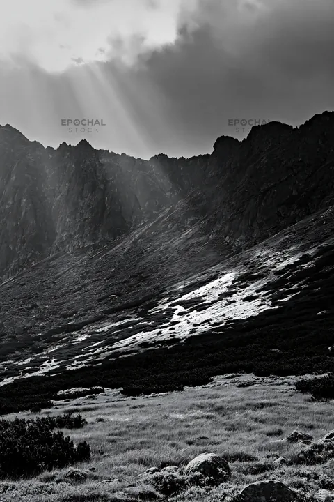 Black and white meadow mountain sunrays shining through the clouds - AI-generated stock image