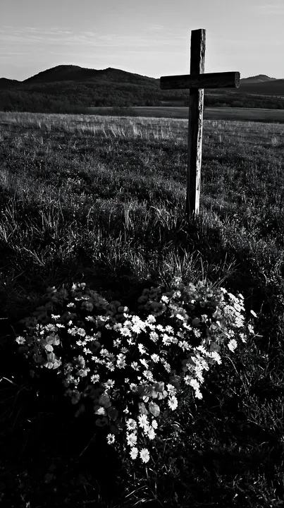 Christian cross in meadow with flowers at sunrise - AI-generated stock image