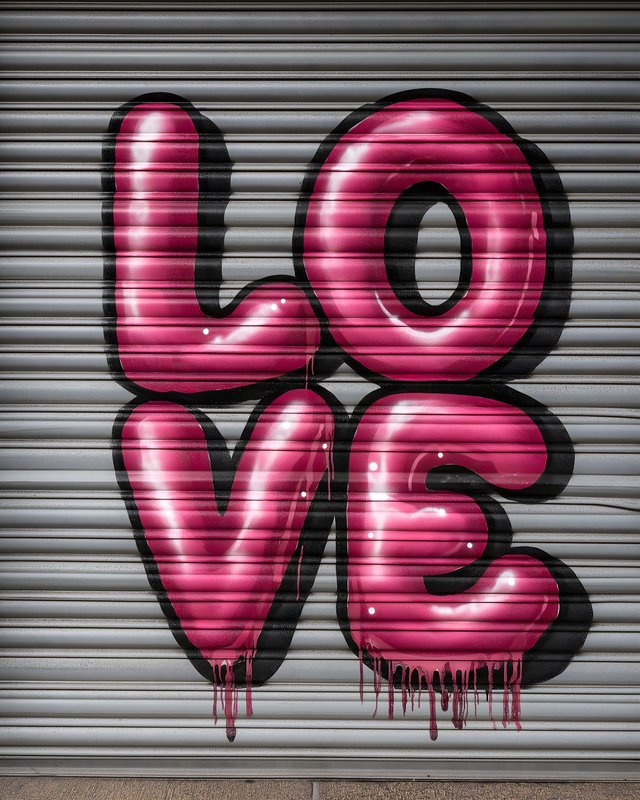 Large pink love graffiti on a roller shutter in an urban area Free Premium Stock Image - stock photo