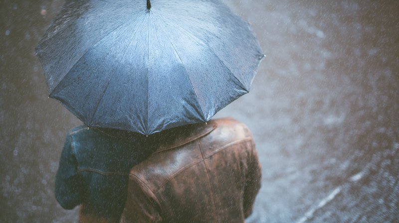 People walking together under an umbrella in the rain Free Premium Stock Image - stock photo