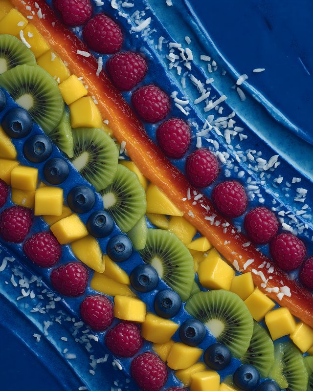 Colorful fruit arrangement on a blue dessert surface Free Premium Stock Photo - stock photo