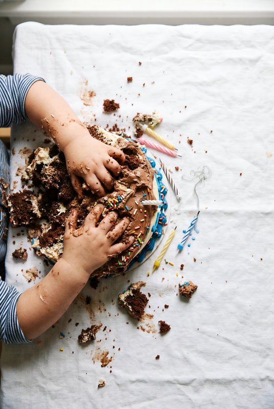 Child enjoys messy cake at birthday party with friends Premium Stock Photo - stock photo