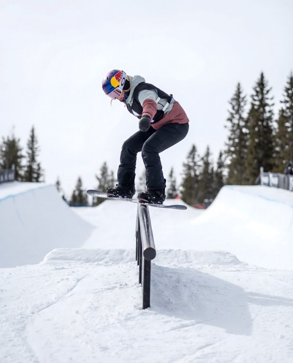 Snowboarder performs tricks on rail in winter sport event - stock photo