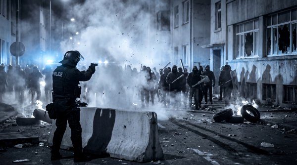 Protests occur in the city at night with police and crowds facing off - stock photo