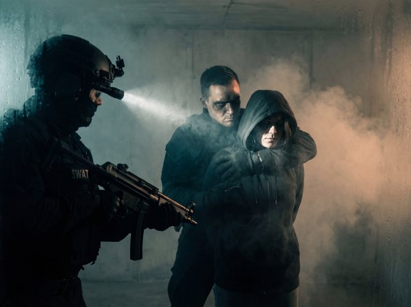 Police team conducts arrest in a smoke-filled room during training - stock photo