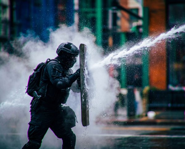 Police use water cannons for crowd control at urban protest - stock photo