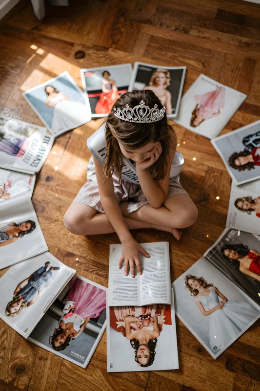 Girl sitting on floor with magazines and a book Premium Stock Photo - stock photo