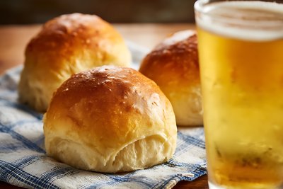 Golden Bierocks Pastry Rolls with Craft Beer on Checkered Kitchen Cloth - stock photo