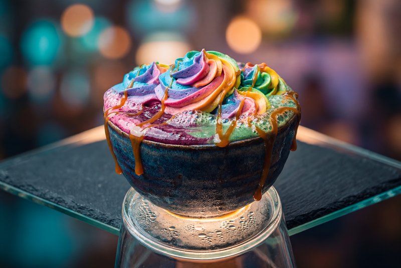 Colorful dessert served in a bowl with syrup drizzle Premium Stock Image - stock photo