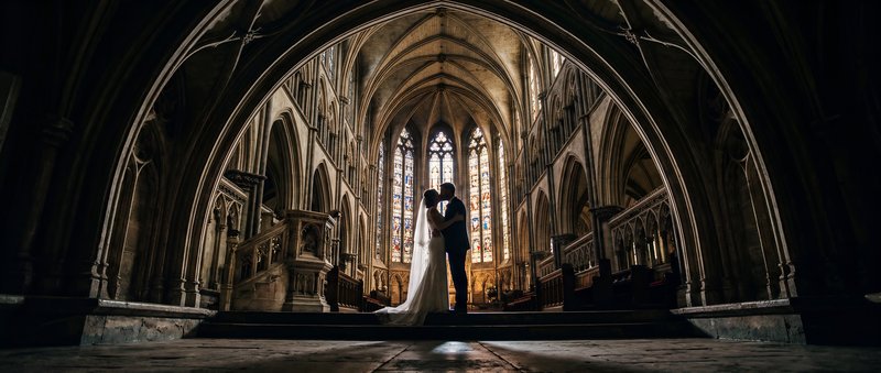 Couple shares a kiss inside a large church during their wedding Premium Stock Image - stock photo