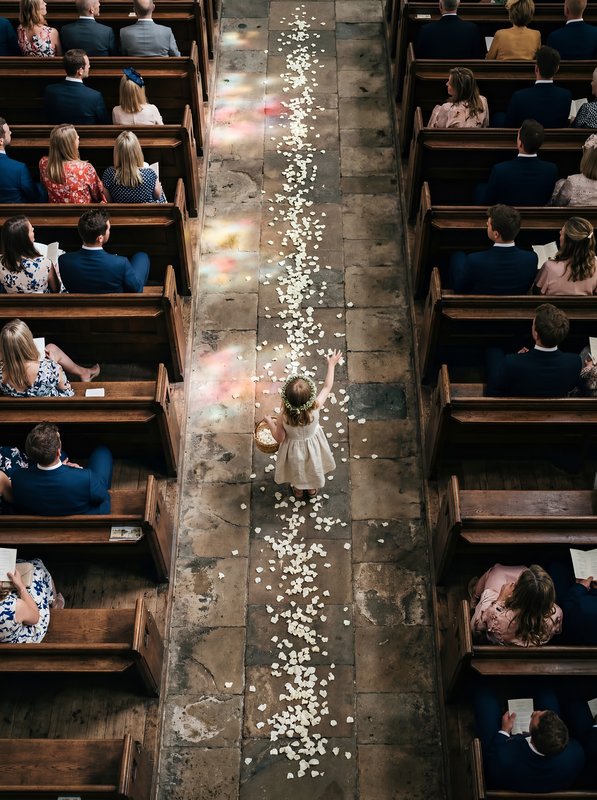 Flower girl walks down aisle during wedding ceremony Premium Stock Photo - stock photo