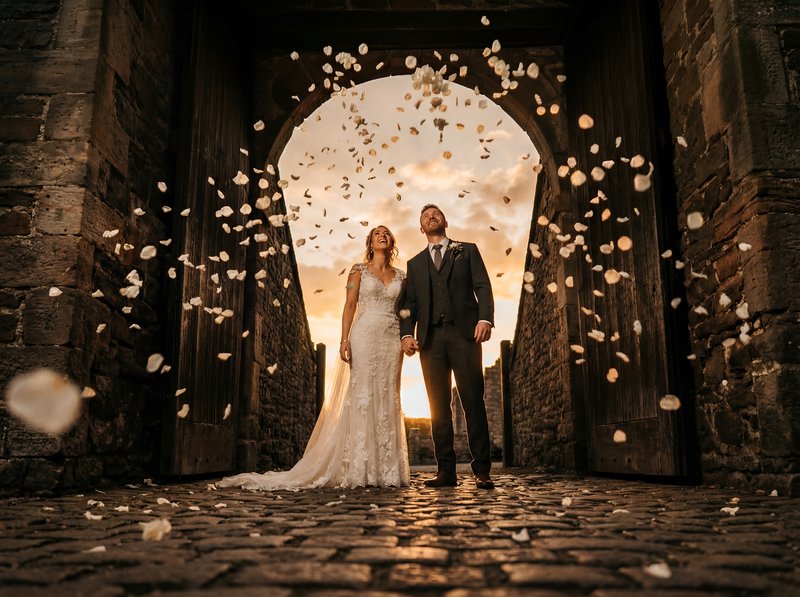 Couple stands together as petals fall at sunset Premium Stock Image - stock photo