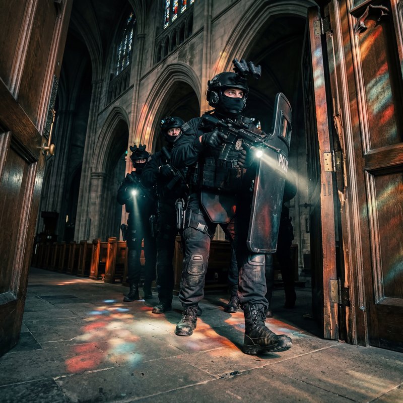 Police officers enter building with shields and flashlights Premium Stock Photo - stock photo