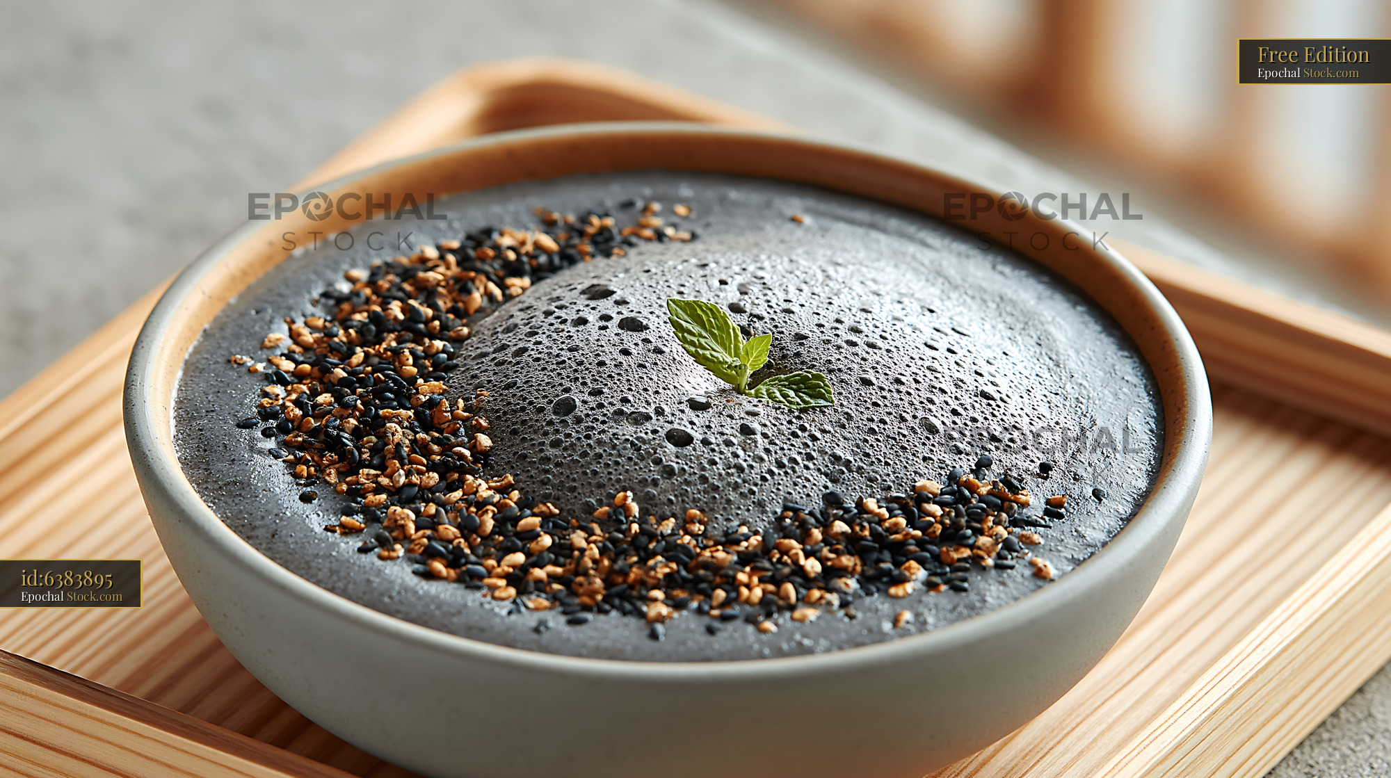 Kurogoma smoothie bowl topped with black sesame seeds and fresh mint - stock photo