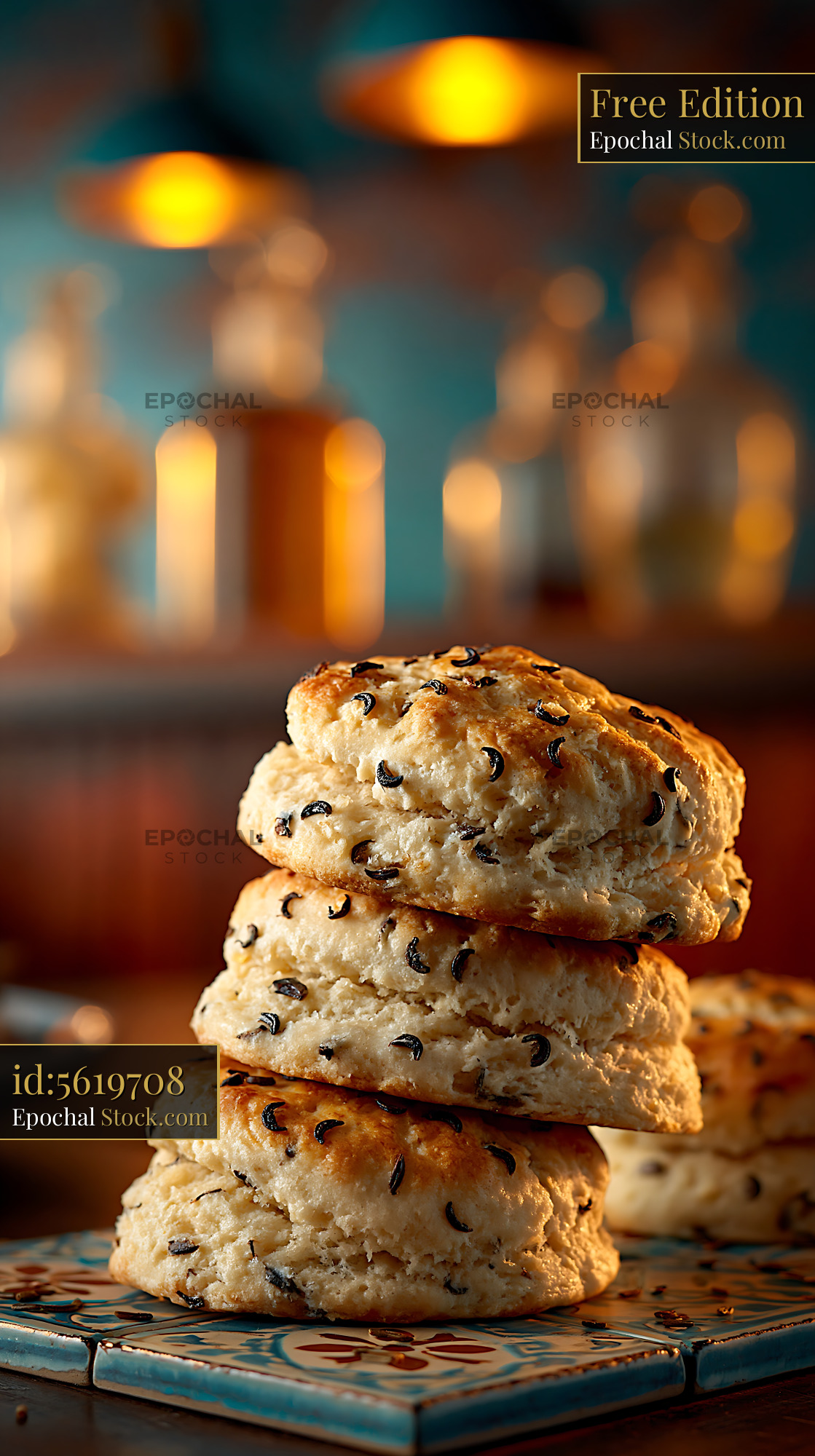 Freshly baked caraway seed biscuits stacked on a decorative tile - stock photo