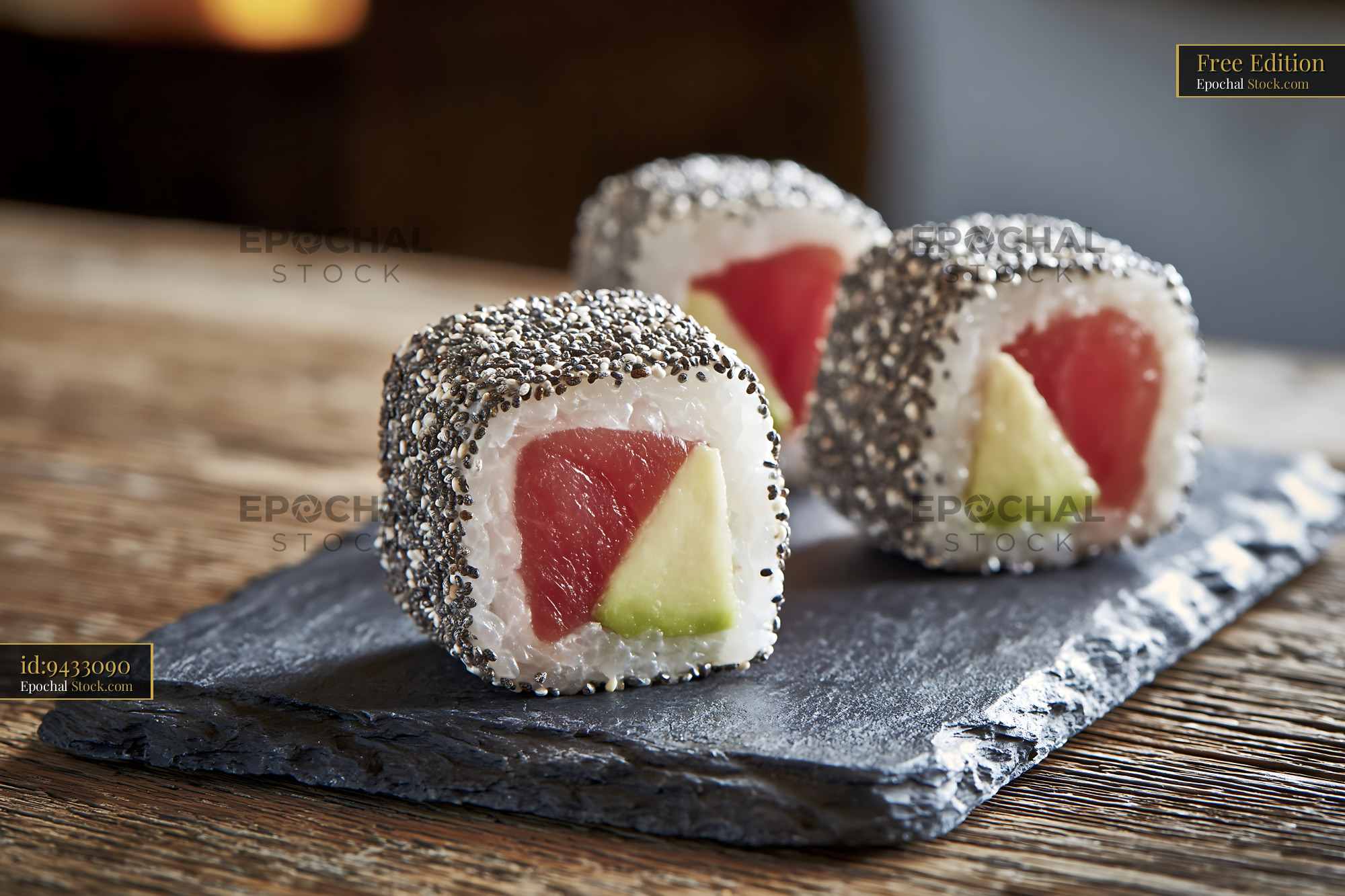 Chia seed crusted sushi rolls with fresh tuna and avocado on slate - stock photo