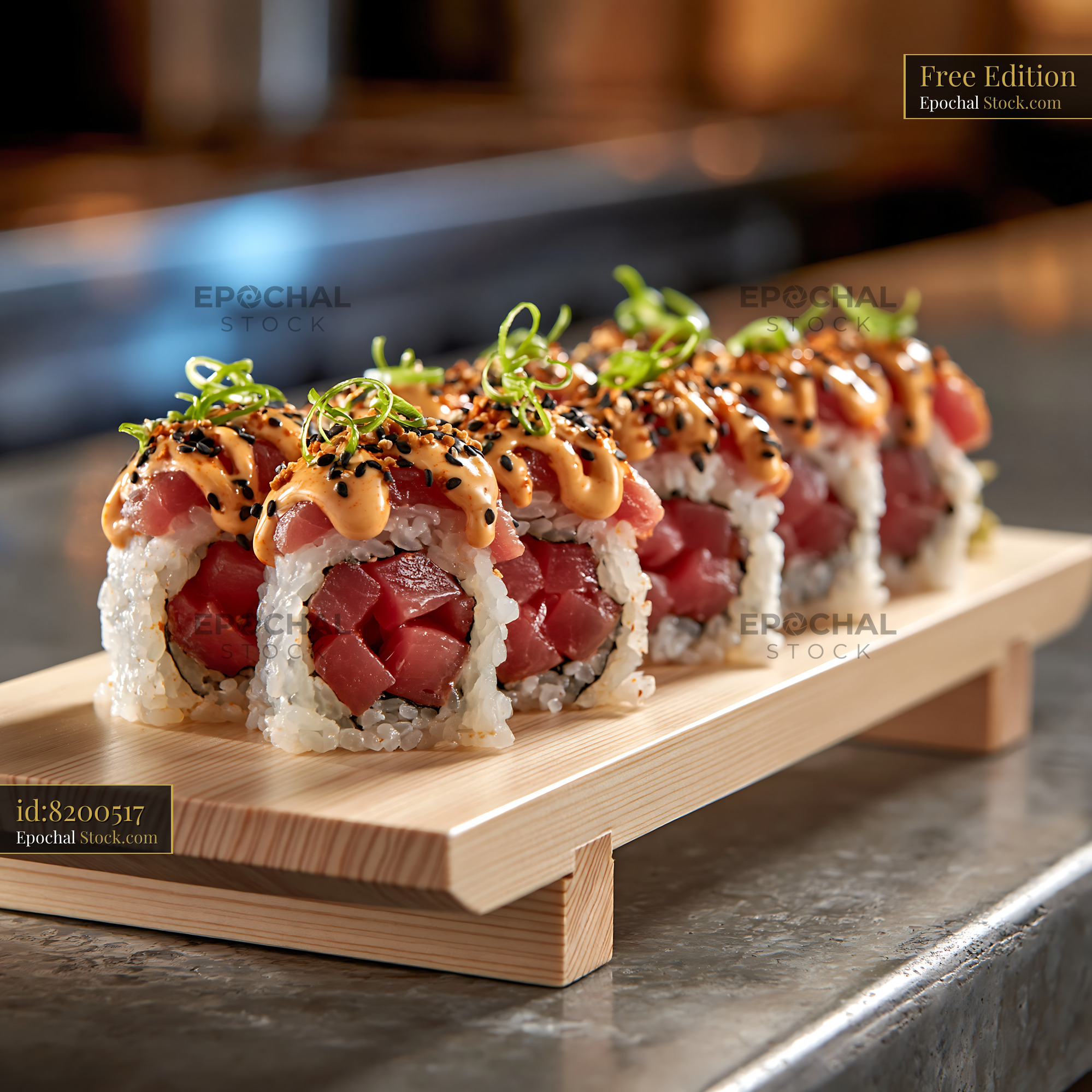 Spicy tuna sushi rolls with sriracha mayo on wooden serving board - stock photo