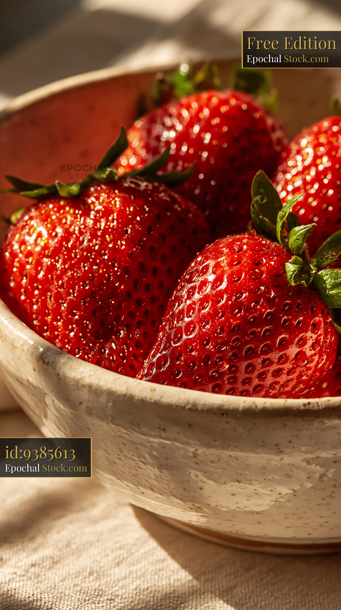Fresh strawberries in a ceramic bowl under warm sunlight - stock photo