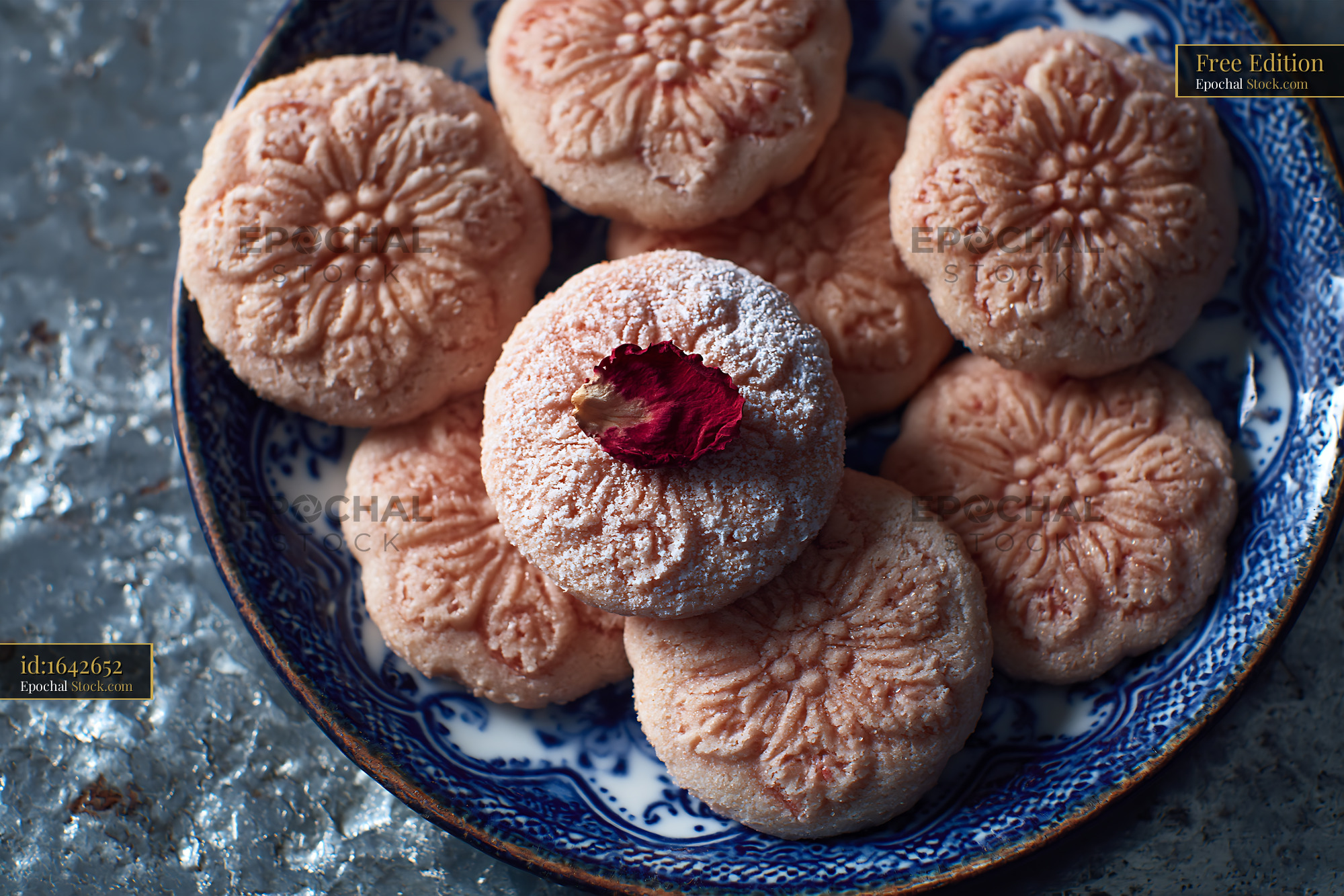 Rose water biscuits with floral patterns on a blue ceramic plate - stock photo
