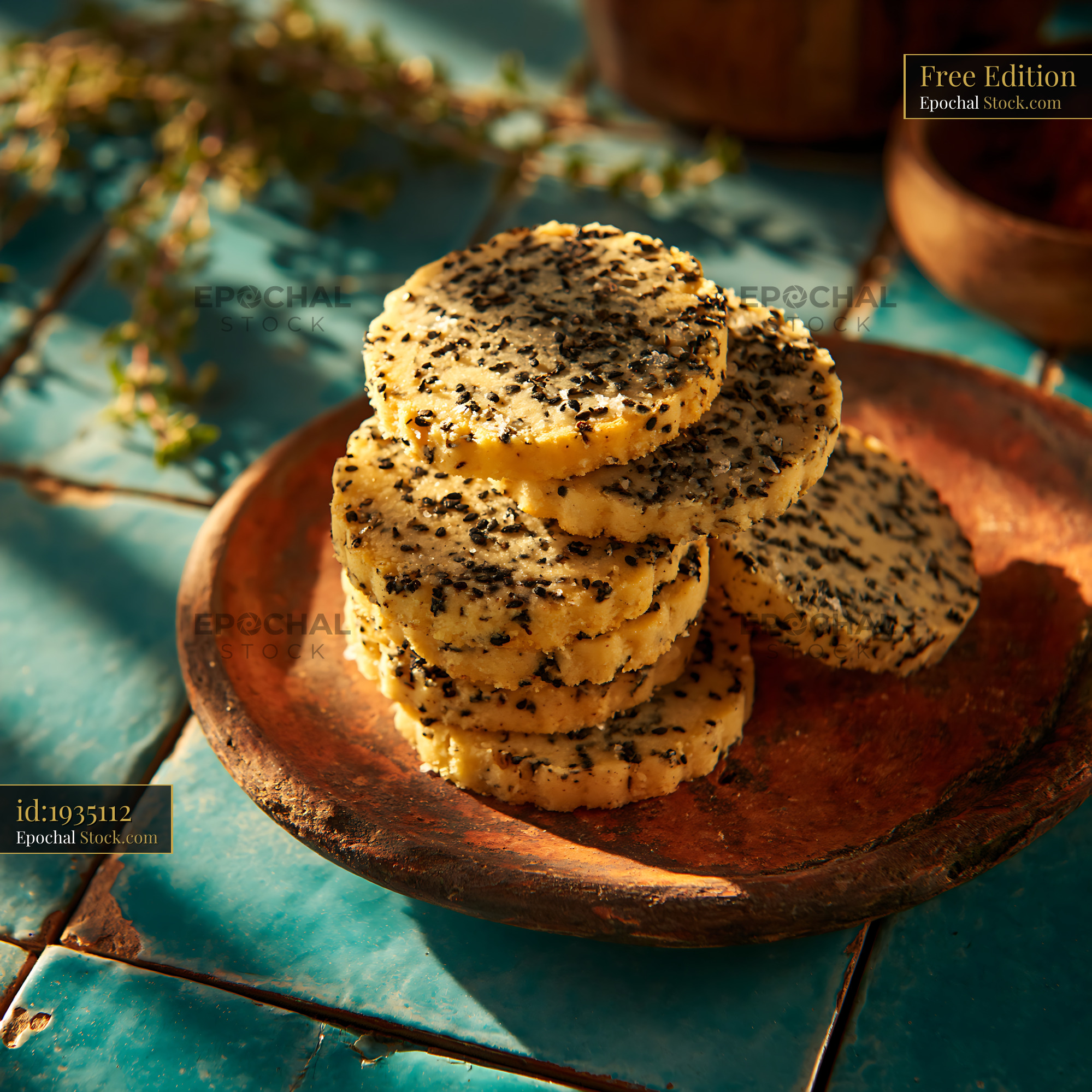 Savory nigella seed biscuits on rustic plate in warm sunlight - stock photo