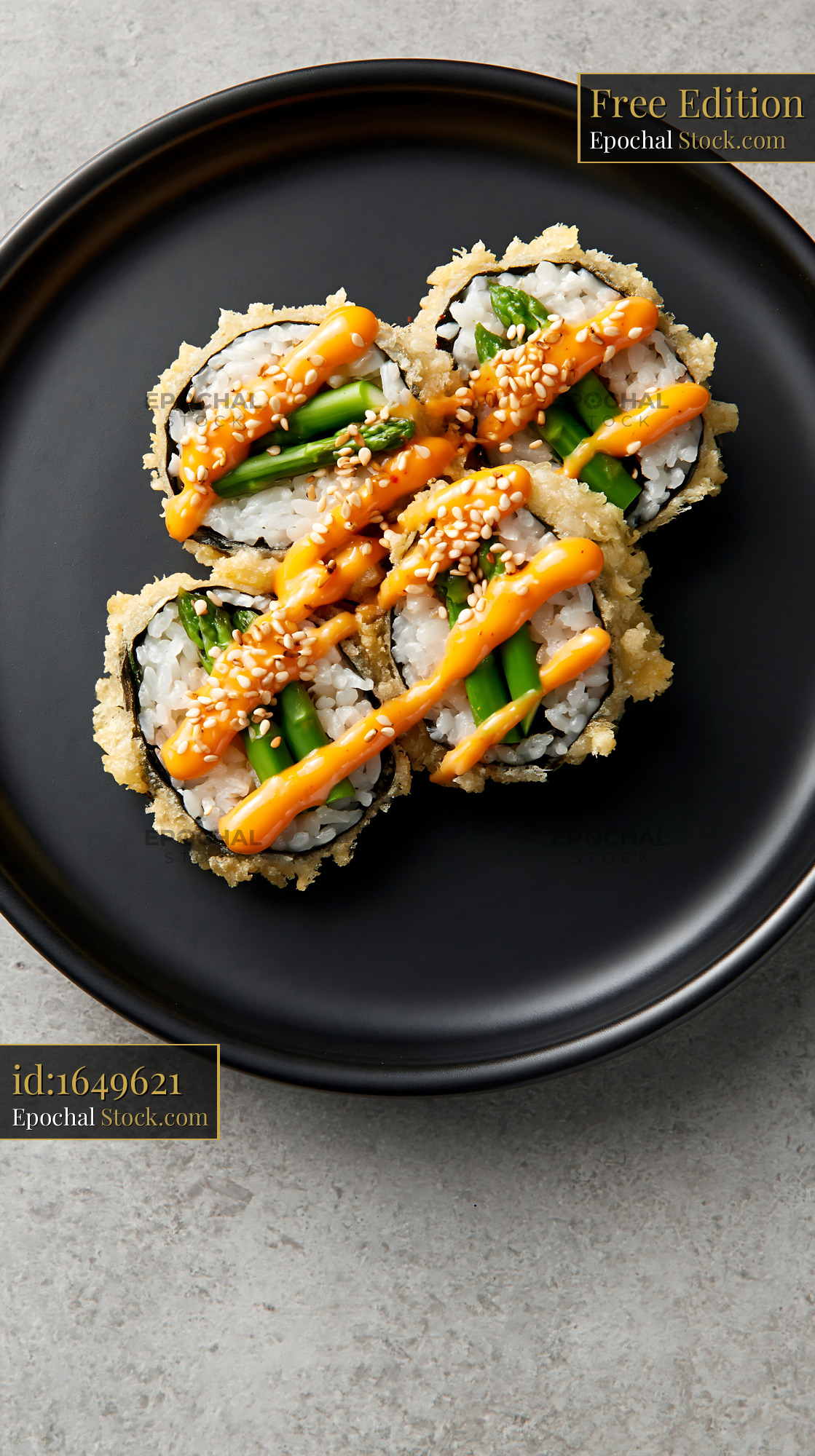 Tempura asparagus sushi rolls with spicy mayo on a black plate - stock photo