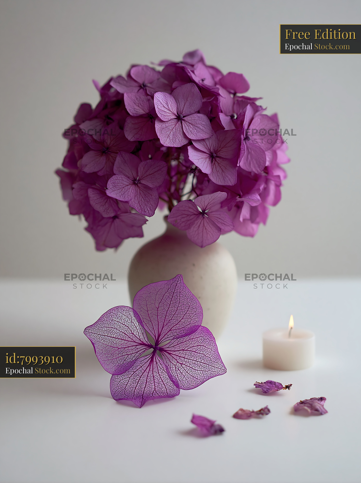 Purple hydrangea bouquet in white vase with skeleton leaf and candle - stock photo