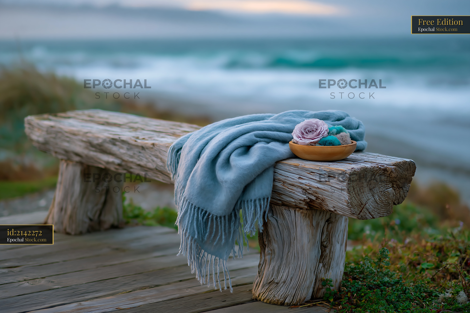 Blue cashmere throw on rustic wooden bench by the ocean - stock photo