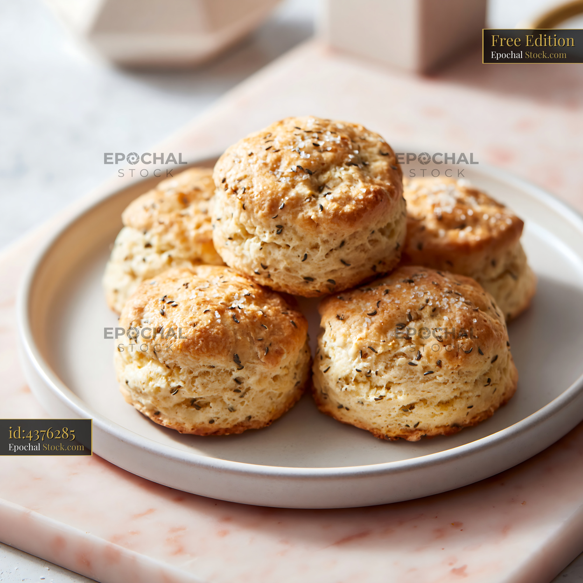 Freshly baked caraway seed biscuits served on a pink marble surface - stock photo