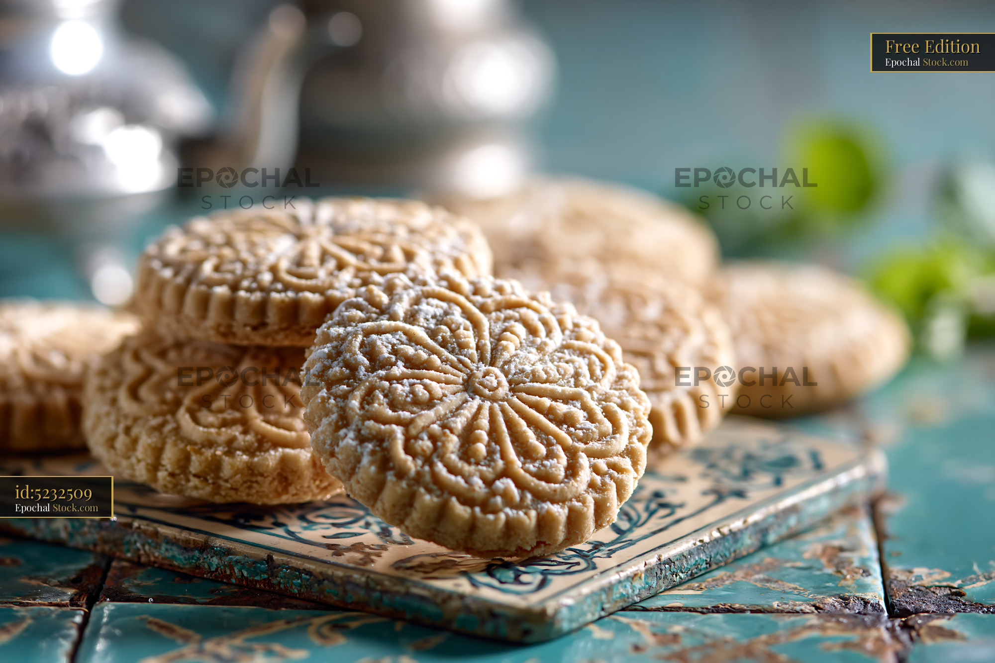 Traditional mahlab spice biscuits with ornate patterns on teal tile - stock photo