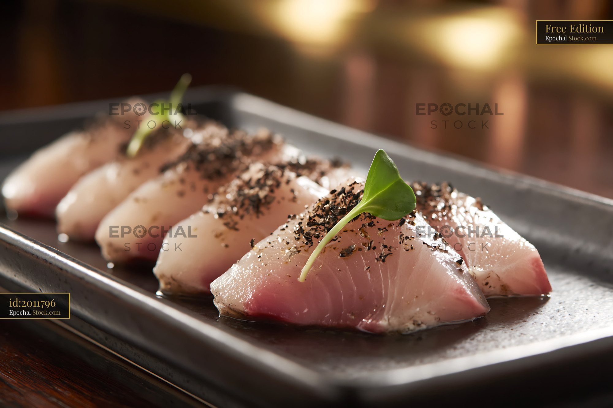 Truffle yellowtail sushi slices on a dark plate in a fine dining setti - stock photo