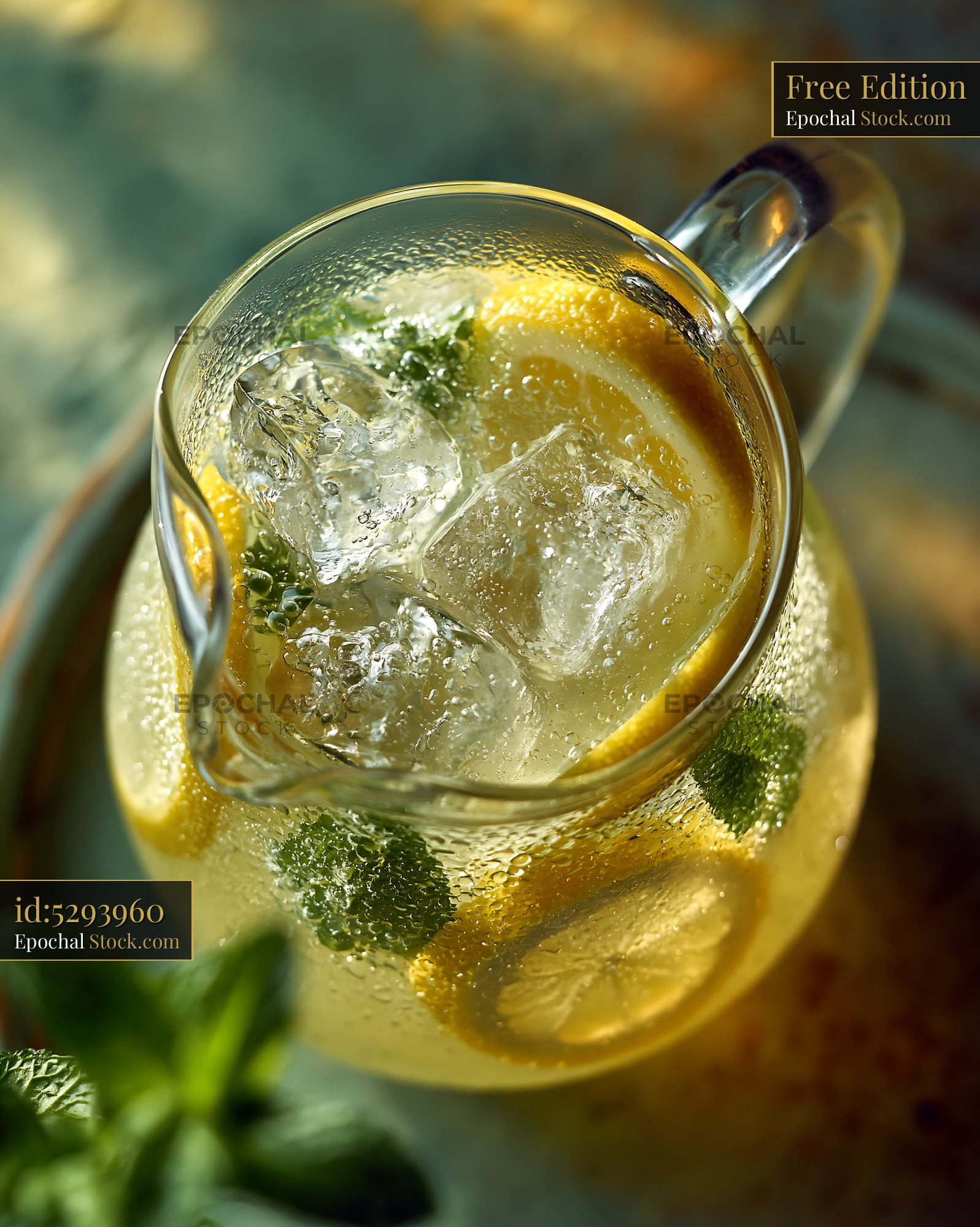 Refreshing lemonade pitcher ice cubes and mint in golden sunlight - stock photo
