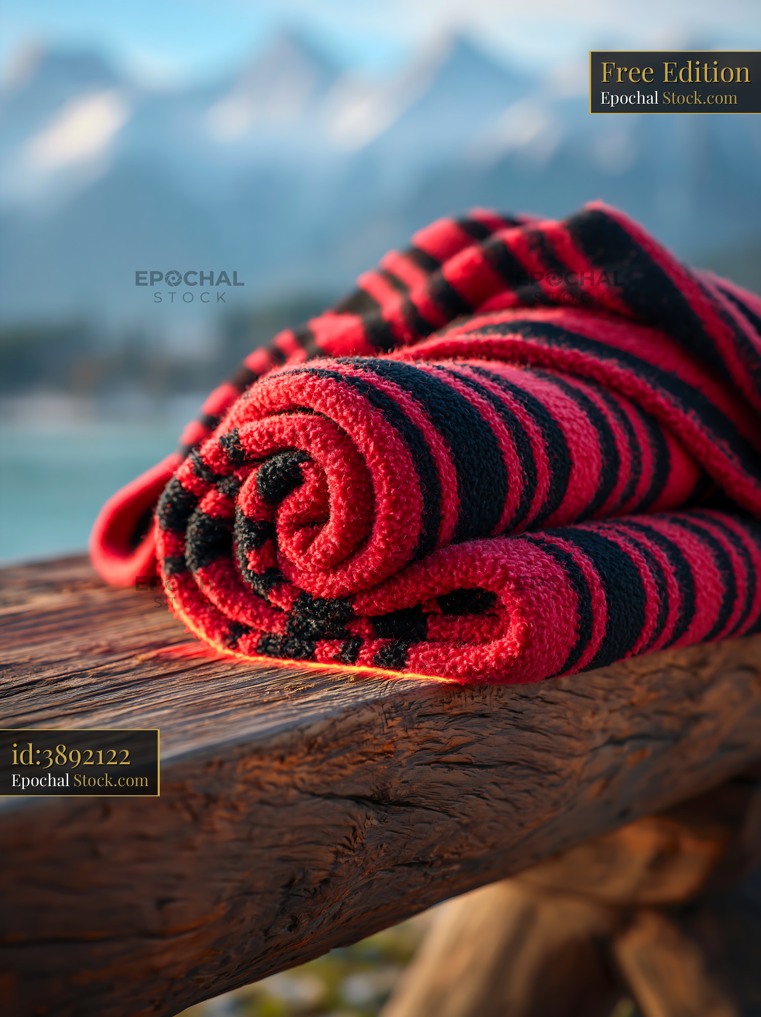 Red and black striped throw on rustic wooden bench with mountains - stock photo