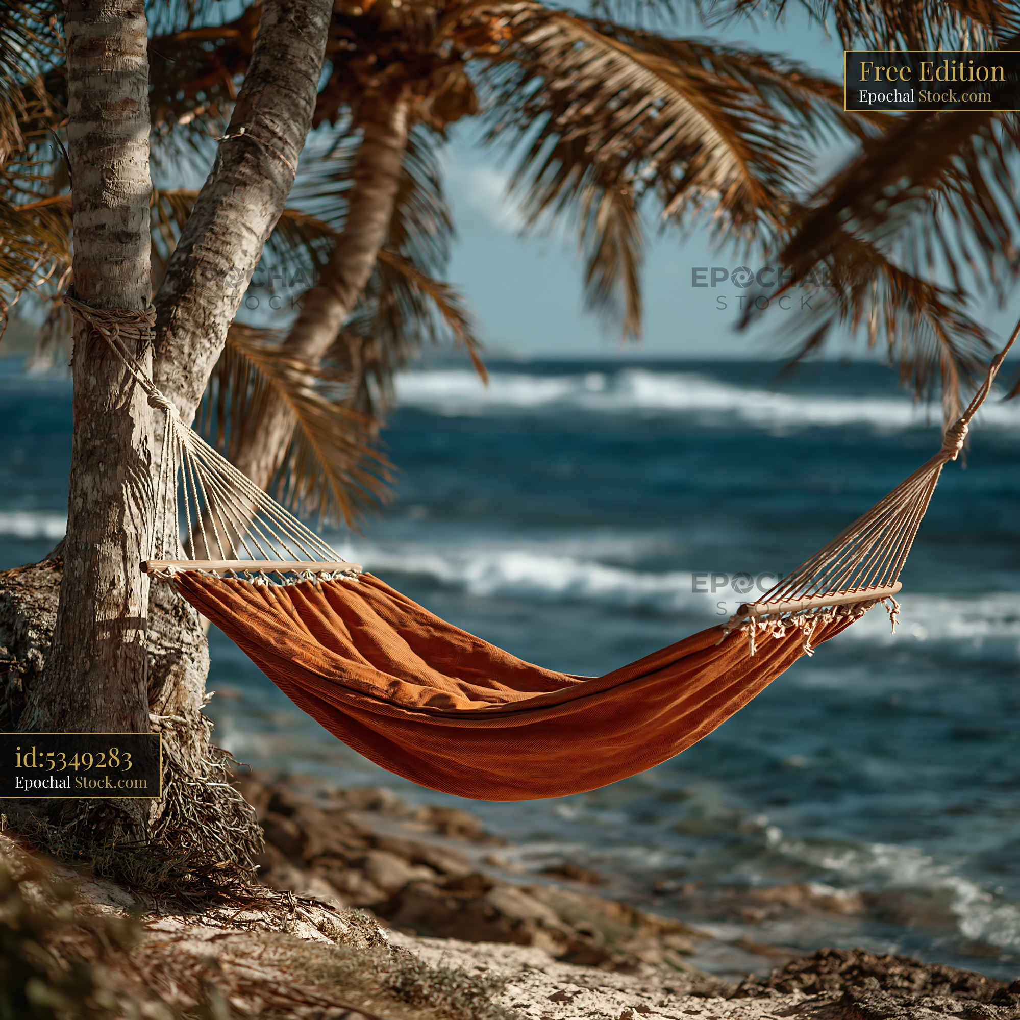 Orange hammock between palm trees on a sunny tropical beach - stock photo