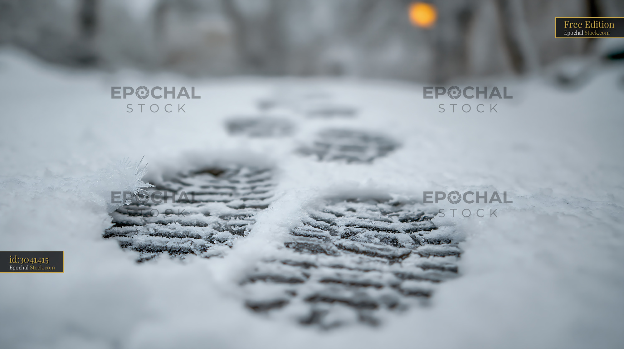 Close up of boot footprints in deep snow during winter sunset - stock photo