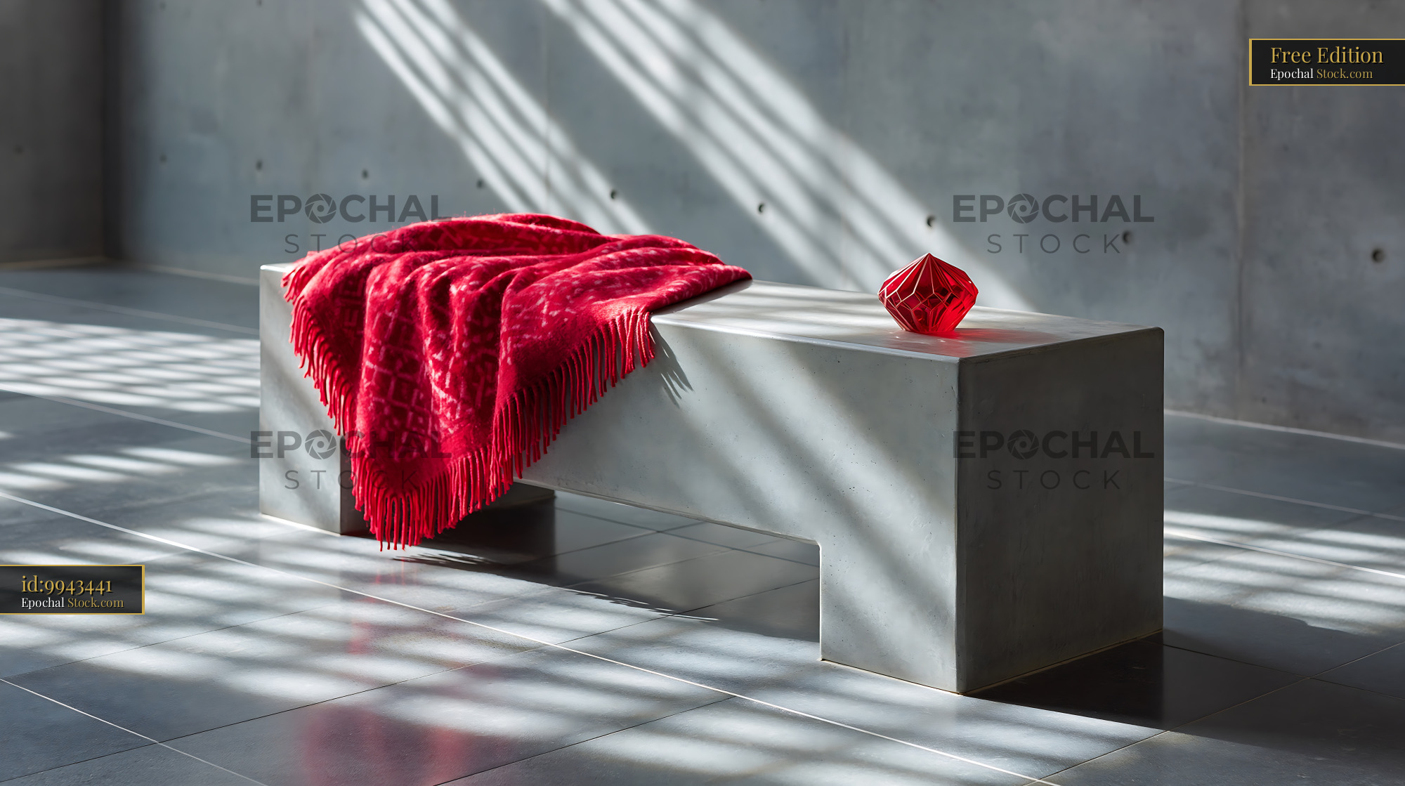 Red throw on bench and glass sculpture in minimalist concrete room - stock photo